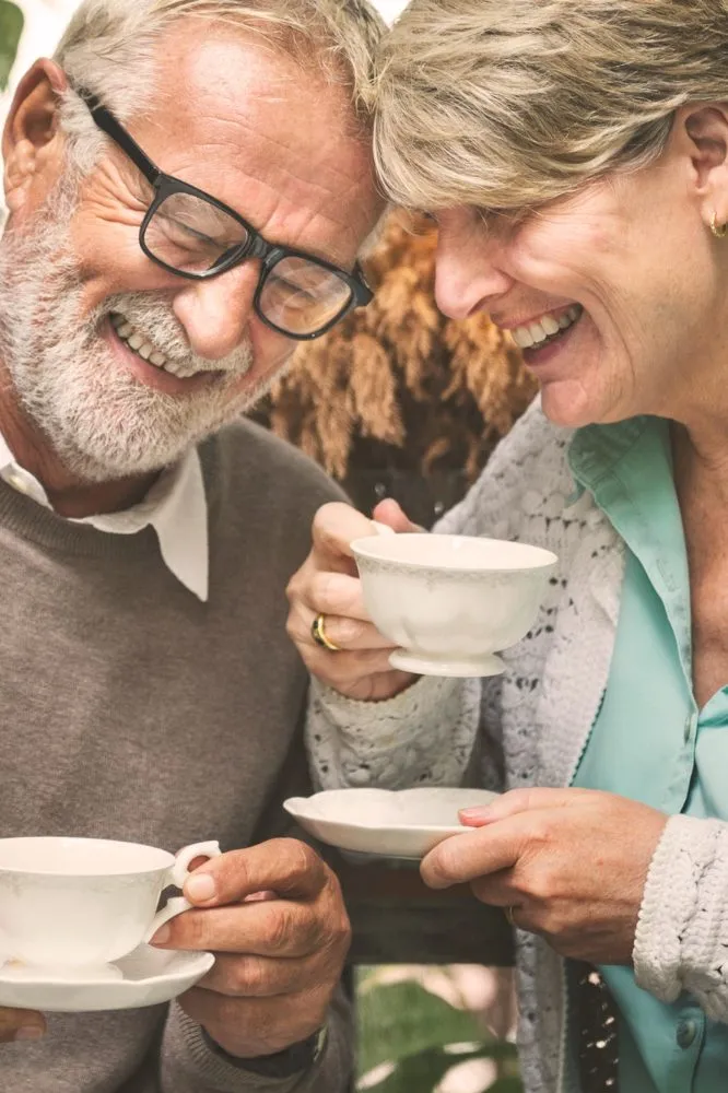 Older couple smiling together over cups of coffee